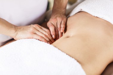 Woman having abdomen massage. clipart
