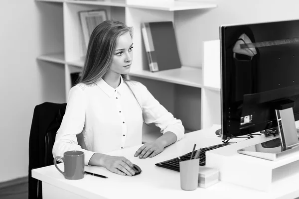 Kobieta siedzi przy biurku z komputera — Zdjęcie stockowe