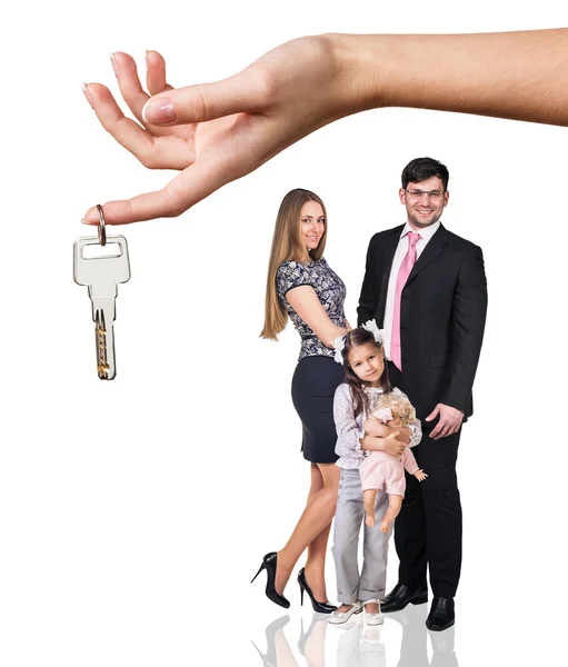 La mano grande da las llaves a la familia joven — Foto de Stock