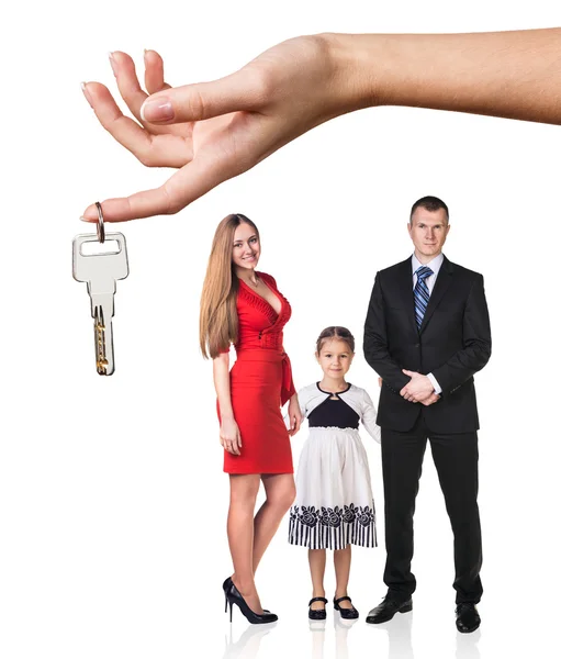 Grande mão dar chaves para a família jovem — Fotografia de Stock