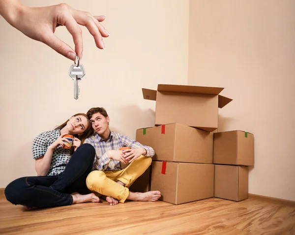 Mano dando un clave joven pareja — Foto de Stock