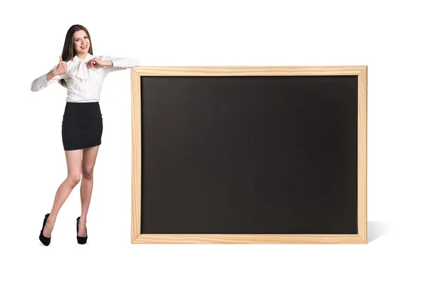 Mladá žena stojí poblíž velké tabuli — Stock fotografie
