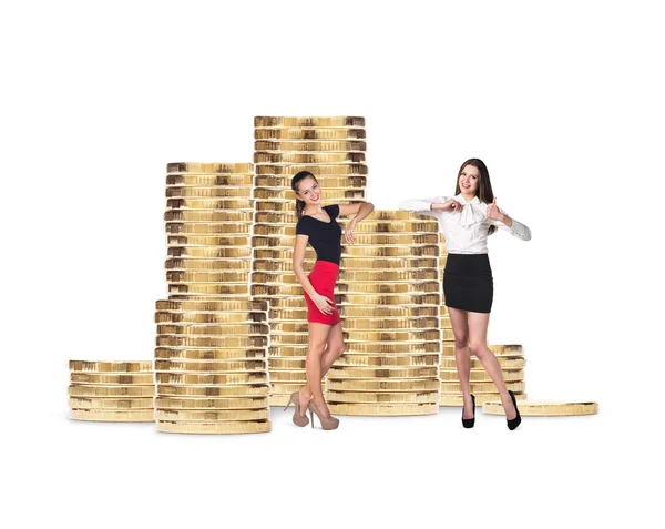 Mujeres de negocios cerca de pila de monedas de oro —  Fotos de Stock