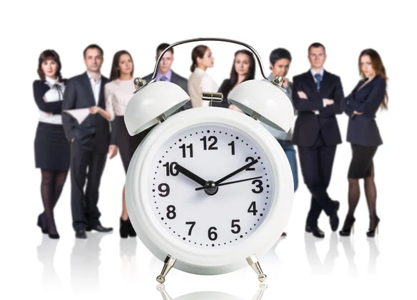 Business people stand near big alarm clock — Stock Photo, Image