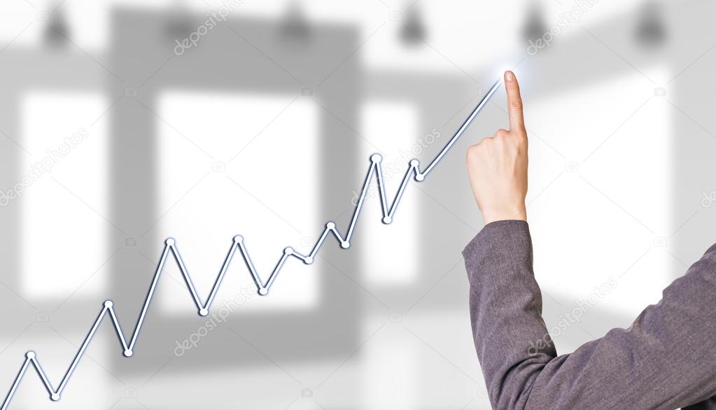 Businesswoman hand drawing a graph