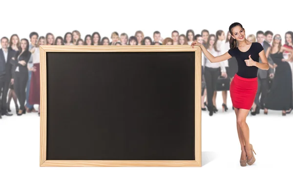 Ung kvinna står nära stora svarta tavlan — Stockfoto