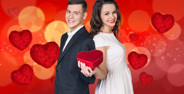 Young couple stands on bokeh valentine background — Stock Photo, Image