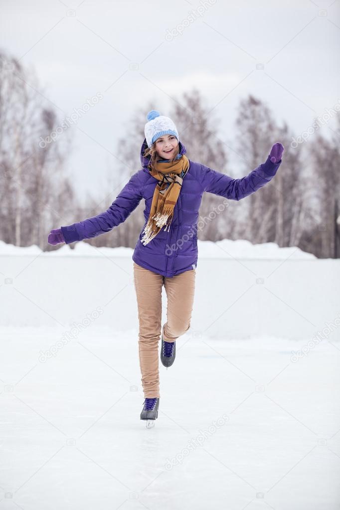 Young woman skating on ice with figure skates
