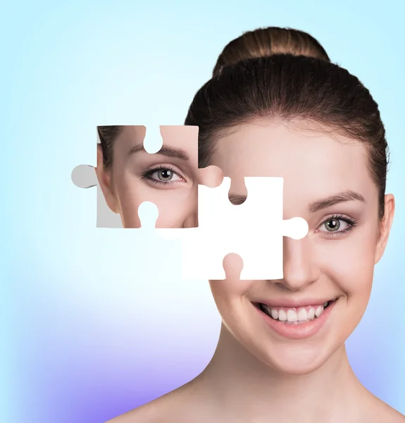 Volto di bella giovane donna con un puzzle parti — Foto Stock