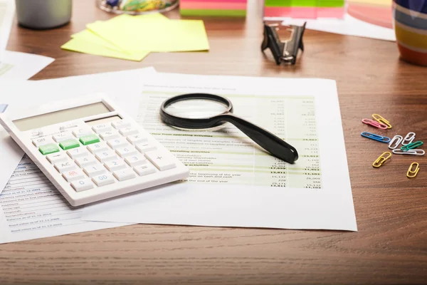 Calculator and magnifying glass on the table — Stock Photo, Image