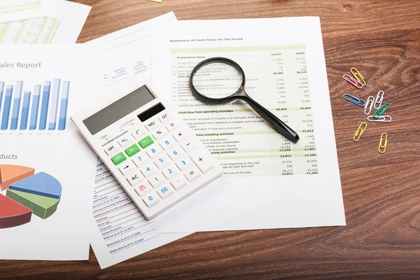 Calculator and magnifying glass on the table — Stock Photo, Image