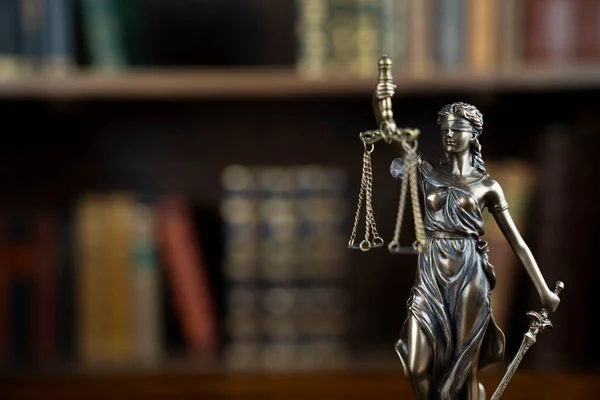 法と正義の概念 判事室だ 茶色の机の上のテーマ彫刻 書棚における法律書の収集 — ストック写真