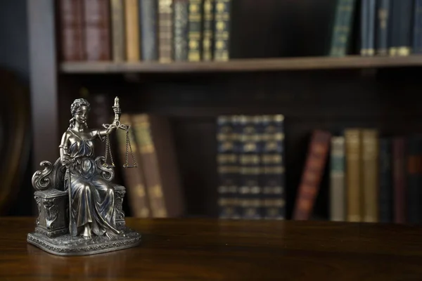法律和司法概念 法官室 这个雕塑在棕色的桌子上 书架上法律书籍的收藏 — 图库照片