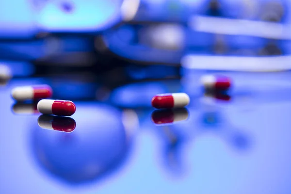 Healthcare concept. Stethoscope and medicines. Blue table and background.