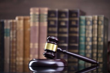 Hukuk teması. Yargıç odası. Hakimler kahverengi masa ve kahverengi arka planda hukuk kitaplarının toplanması ve tokmağı..