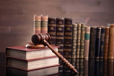 Hukuk teması. Yargıç odası. Hakimler kahverengi masa ve kahverengi arka planda hukuk kitaplarının toplanması ve tokmağı..