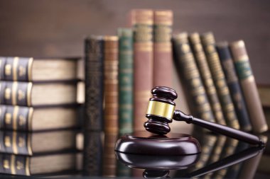 Hukuk teması. Yargıç odası. Hakimler kahverengi masa ve kahverengi arka planda hukuk kitaplarının toplanması ve tokmağı..