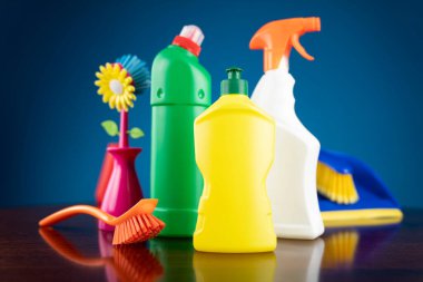 Ev ve ofis temizliği teması. Mavi arkaplanda renkli temizlik kiti.