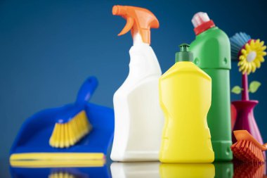 Ev ve ofis temizliği teması. Mavi arkaplanda renkli temizlik kiti.