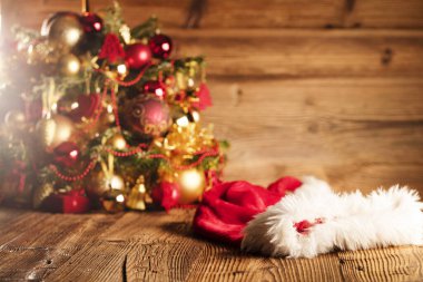 Noel Baba günü konsepti. Altın ve kahverengimsi estetik ve Noel Baba şapkasıyla Noel süslemesi. Tipografi veya metin için yer. 