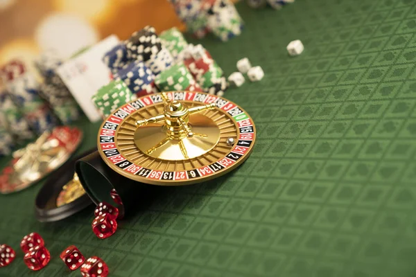 赌场的概念 轮盘赌 扑克筹码和骰子放在绿色桌子上和黄色底盘上 — 图库照片