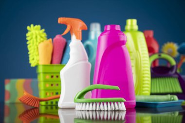 Ev ve ofis temizliği teması. Mavi arkaplanda renkli temizlik kiti.