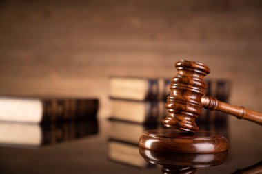 Hukuk teması. Yargıç tokmak ve kahverengi arkaplan üzerine hukuk kitapları koleksiyonu. 