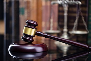 Hukuk teması. Yargıç odası. Kahverengi masa ve kahverengi arkaplan üzerinde hakimler tokmak, ölçek ve hukuk kitapları koleksiyonu.