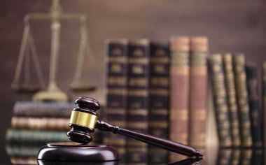 Hukuk teması. Yargıç odası. Kahverengi masa ve kahverengi arkaplan üzerinde hakimler tokmak, ölçek ve hukuk kitapları koleksiyonu.