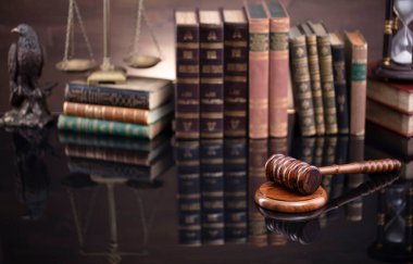 Hukuk teması. Yargıç odası. Kahverengi masa ve kahverengi arkaplan üzerinde hakimler tokmak, ölçek ve hukuk kitapları koleksiyonu.