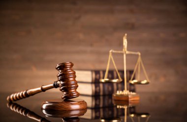 Kahverengi arka planda hukuk sembolleri. Gavel, ölçü, hukuk kitapları ve heykel. Metin için yer.