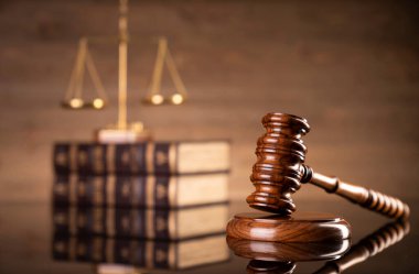 Kahverengi arka planda hukuk sembolleri. Gavel, ölçü, hukuk kitapları ve heykel. Metin için yer.