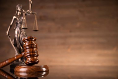 Kahverengi arka planda hukuk sembolleri. Gavel, ölçü, hukuk kitapları ve heykel. Metin için yer.