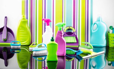 House and office cleaning theme. Colorful set of bottles with clining liquids and colorful cleaning kit on background in the form of colorful stripes. clipart