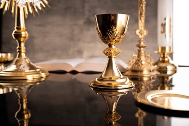Katolik sembolleri kompozisyonu. Din kavramı. Haç, Monstrance, Kutsal İncil ve Altın Kadeh gri arka plan. 