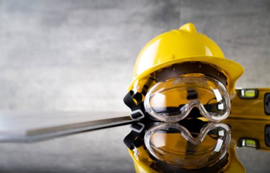 Müteahhit konsepti. Müteahhitin alet çantası: sarı başlık, karalama ve gri arka plandaki araçlar.