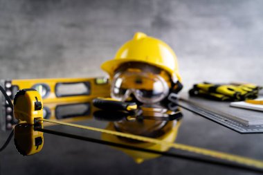 Müteahhit konsepti. Müteahhitin alet çantası: sarı başlık, karalama ve gri arka plandaki araçlar.