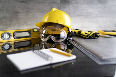 Müteahhit konsepti. Müteahhitin alet çantası: sarı başlık, karalama ve gri arka plandaki araçlar.