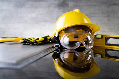 Müteahhit konsepti. Müteahhitin alet çantası: sarı başlık, karalama ve gri arka plandaki araçlar.