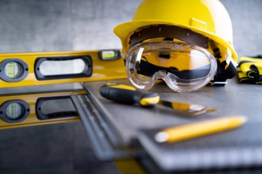 Müteahhit konsepti. Müteahhitin alet çantası: sarı başlık, karalama ve gri arka plandaki araçlar.