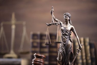 Hukuk teması. Yargıç odası. Hakimler tokmak, ölçü, heykel ve kahverengi masa üzerinde hukuk kitaplarının koleksiyonu..