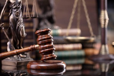 Hukuk teması. Yargıç odası. Hakimler tokmak, ölçü, heykel ve kahverengi masa üzerinde hukuk kitaplarının koleksiyonu..