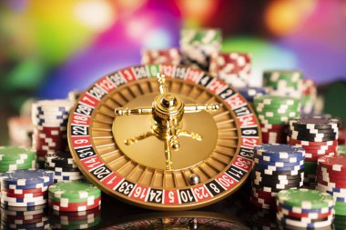 Kumarhane teması. Kumar oyunları. Renkli bir arkaplanda rulet, zar ve poker fişleri.