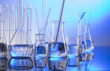 Laboratuvar konsepti. Mavi arka planda cam tüpler ve beherler.