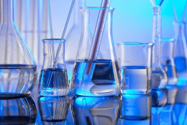 Laboratuvar konsepti. Mavi arka planda cam tüpler ve beherler.