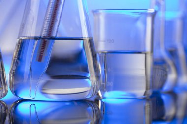 Laboratuvar konsepti. Mavi arka planda cam tüpler ve beherler.