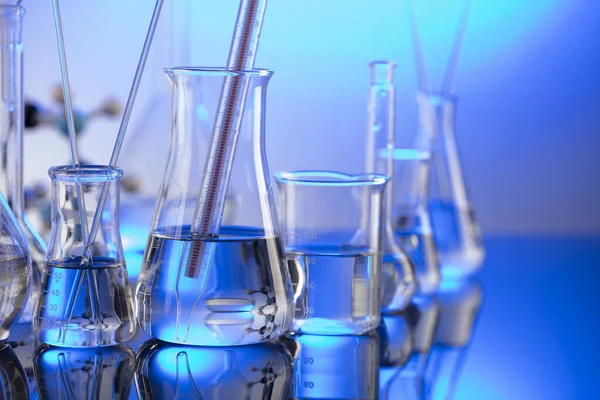 Laboratuvar konsepti. Mavi arka planda cam tüpler ve beherler.