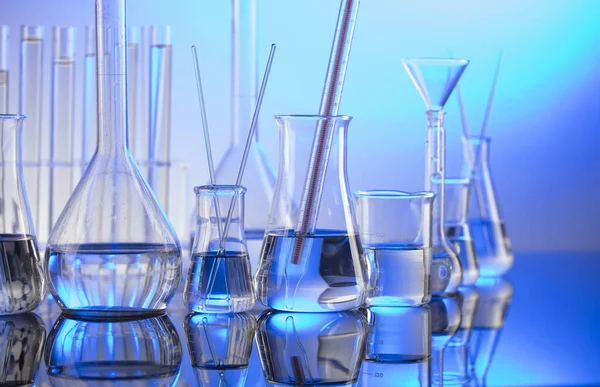 Laboratuvar konsepti. Mavi arka planda cam tüpler ve beherler.