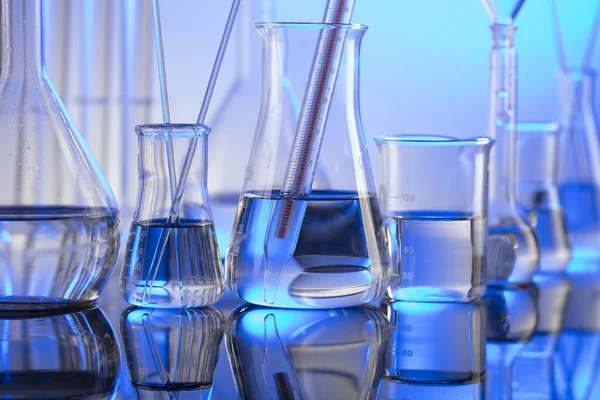 Laboratuvar konsepti. Mavi arka planda cam tüpler ve beherler.