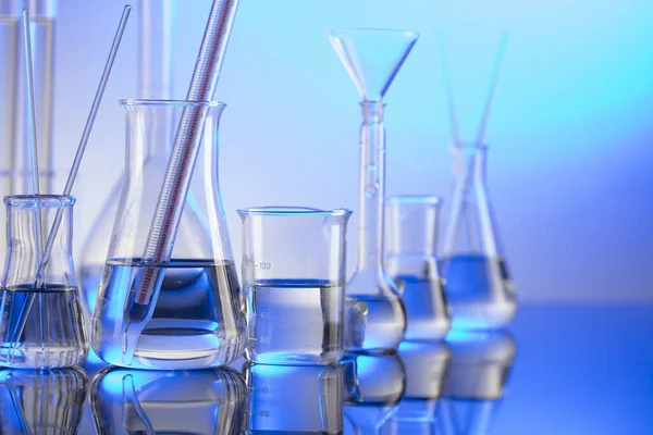 Laboratuvar konsepti. Mavi arka planda cam tüpler ve beherler.